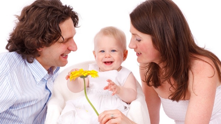 parents with baby and yellow flower