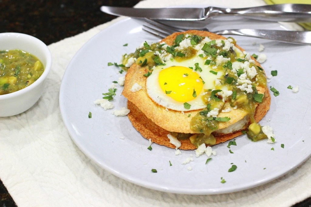 Charred Tomatillo and Avocado Salsa on Eggs hero on white plate