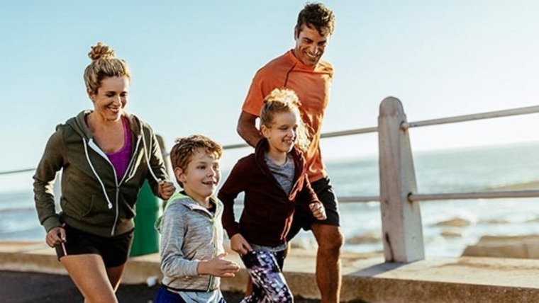 family jogging by the sea