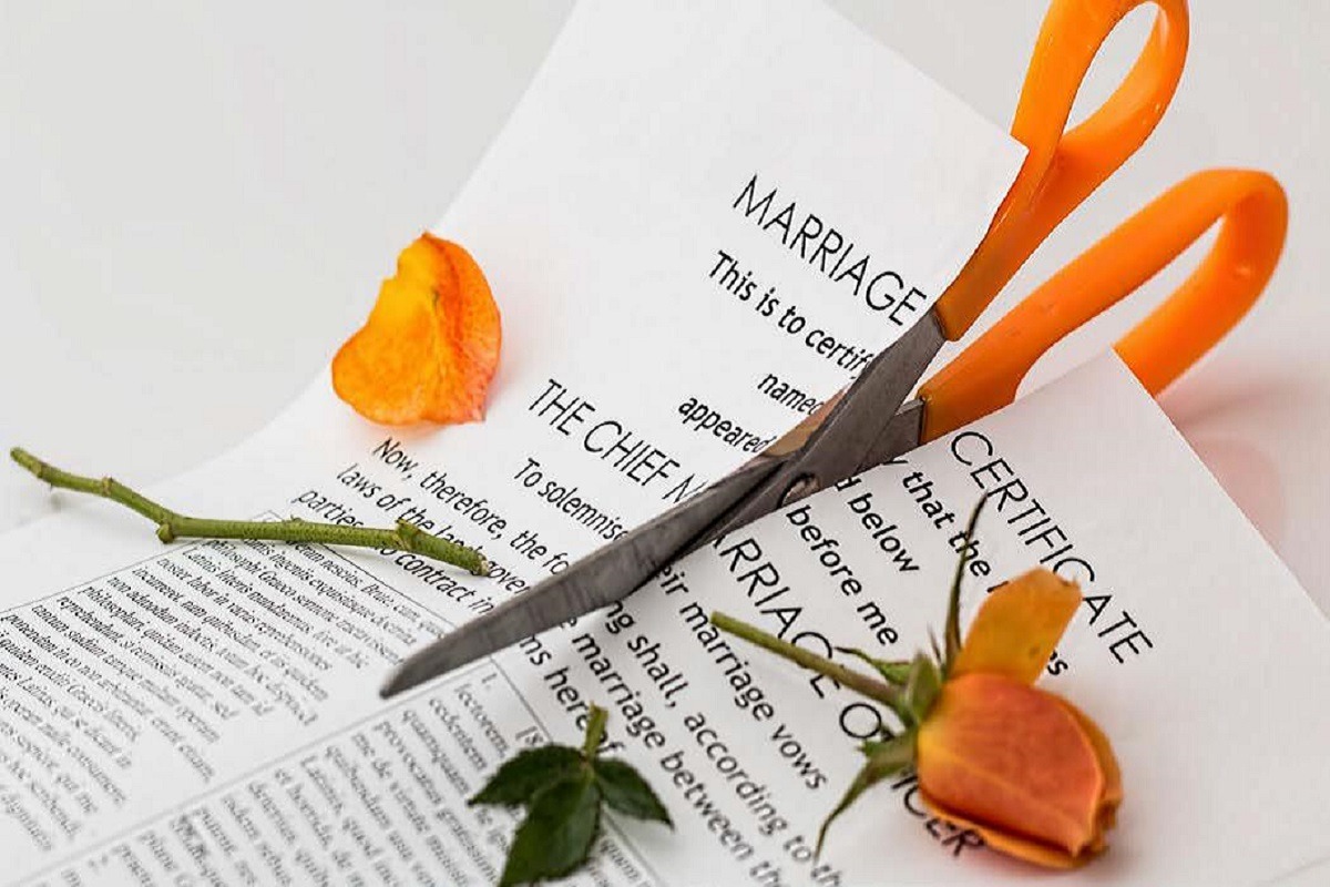 scissors cutting marriage certificate and rose