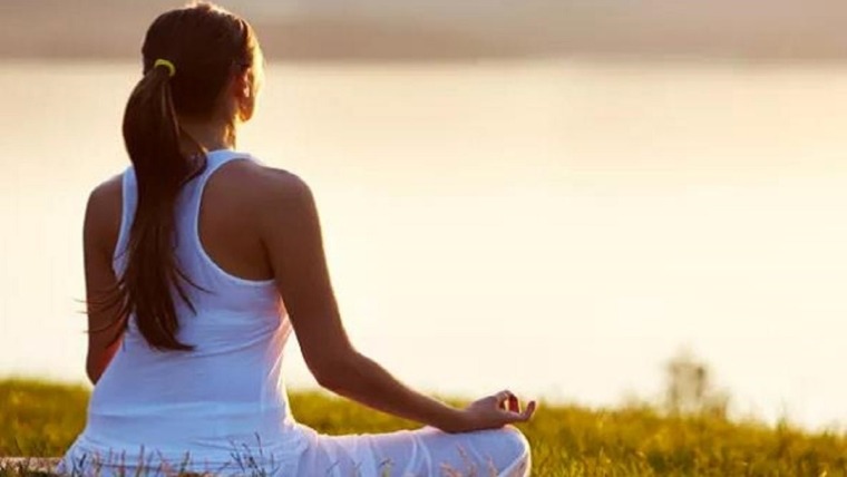 woman sitting in meditation pose outside