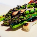 grilled asparagus and leeks on white platter