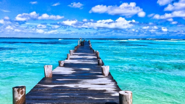 wooden pier disappearing into the blue ocean