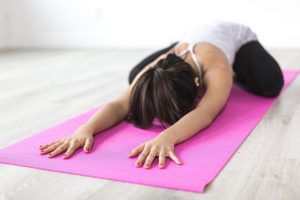 woman stretching yoga on pink mat