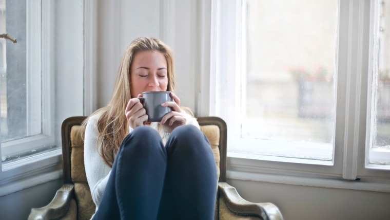 woman with cup of tea sitting in lounge