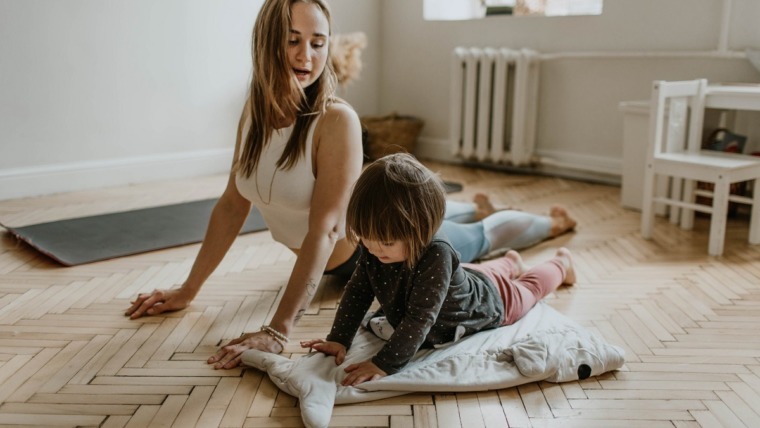 Mother and daughter stretching on floor yoga
