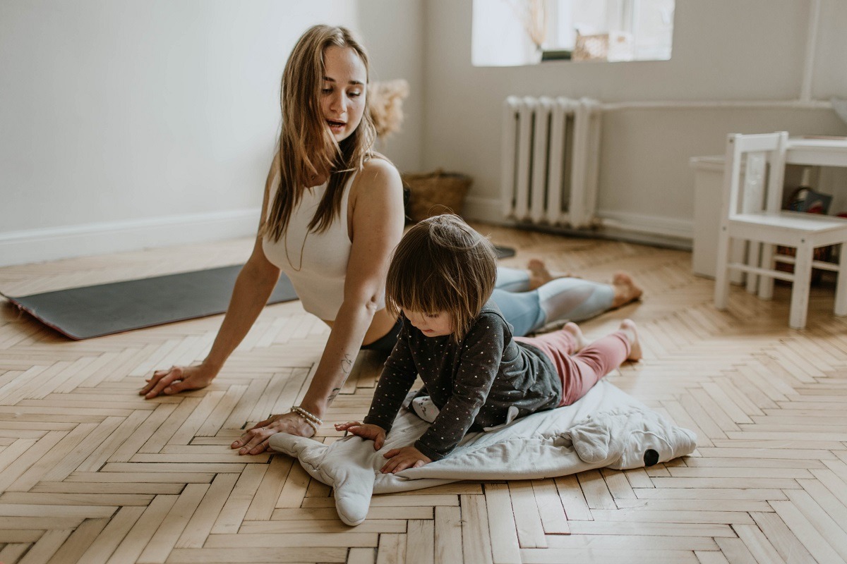 Mother and daughter stretching on floor yoga