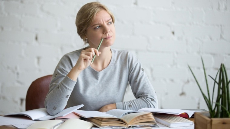 Woman with pencil thinking