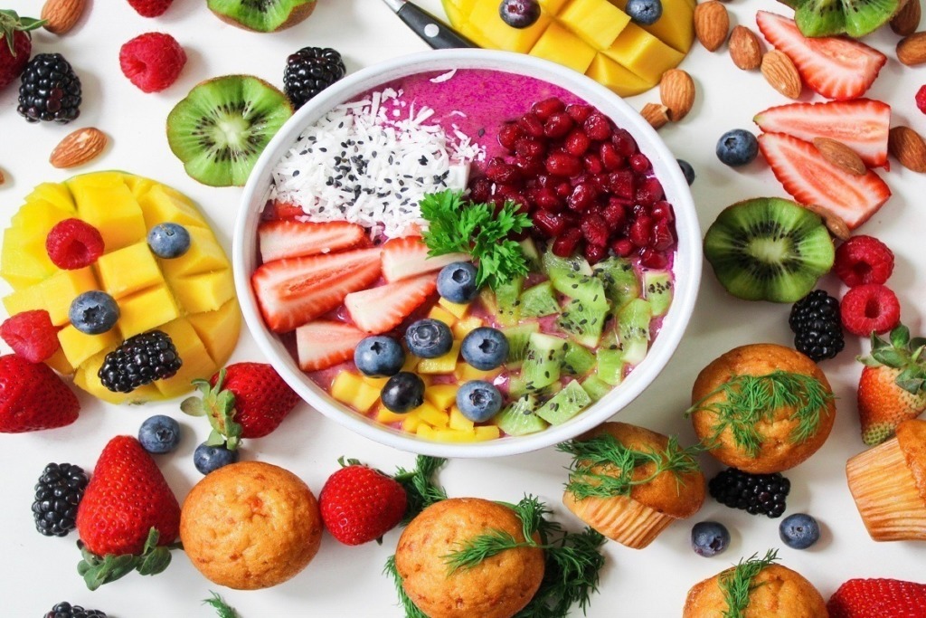 bowl of health food surrounded by fruits