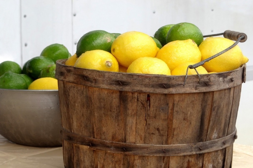 wooden bucket filled with lemons and limes