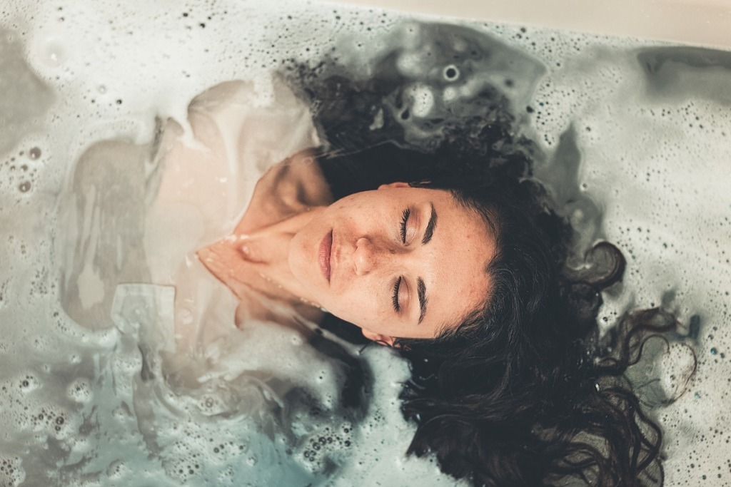 clothed woman in bubble bath