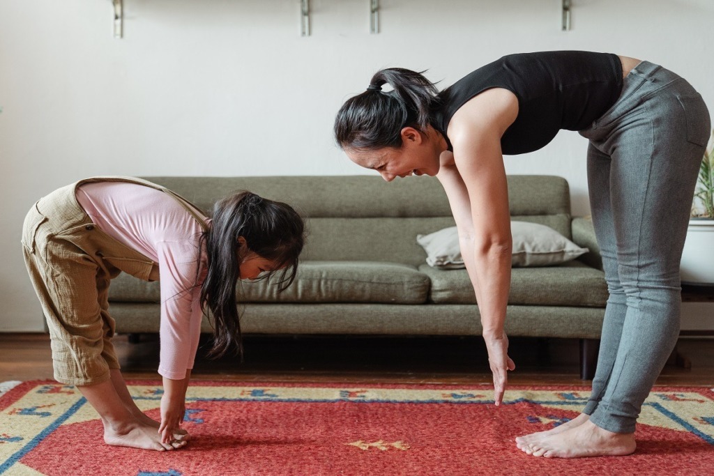 mother and daughter stretching to touch toes