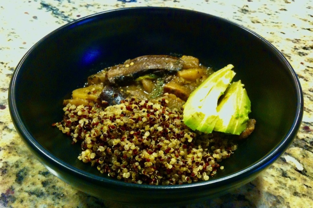 eggplant stew with quinoa in black bowl