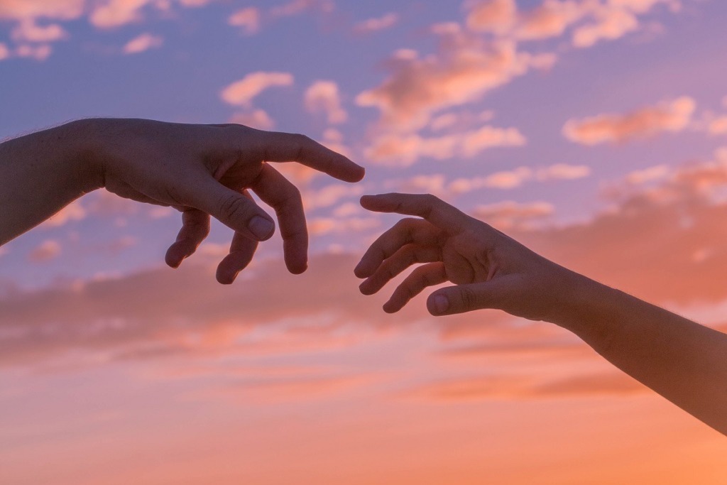 touching hangs with pastel sky backdrop