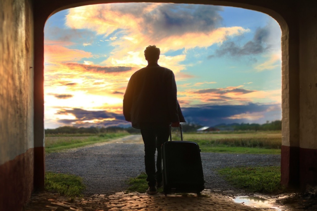 man with suitcase walking into horizon
