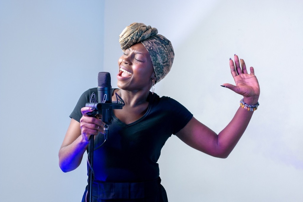 african woman singing into microphone