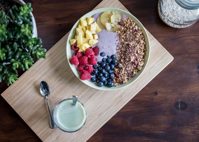 filled breakfast bowl on wooden tray