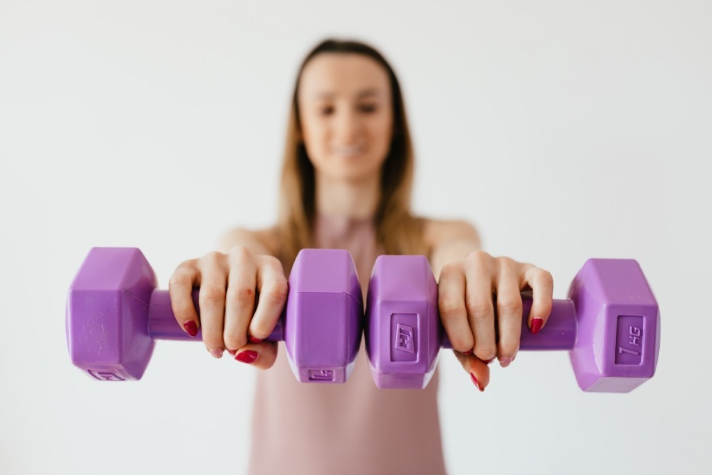 woman holding purple weights