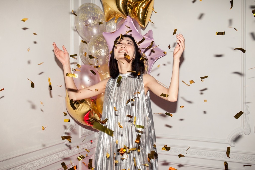 woman celebrating with tinsel and balloons
