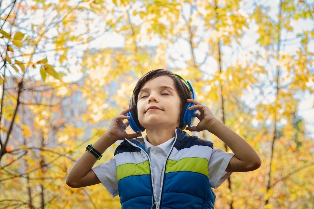 young boy listening to blue headphones