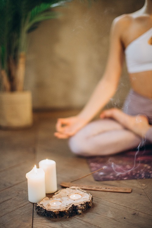 woman in yoga pose with incense and candles