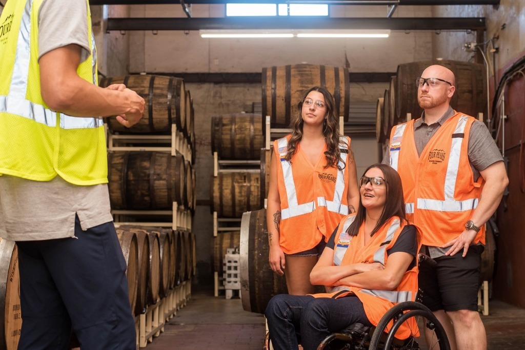 workers, woman in wheelchair listening to Forman