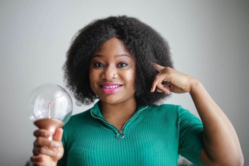 woman in green top holding light globe